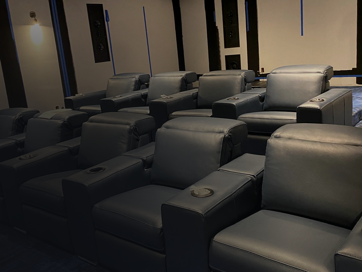 Home theater with tiered leather recliners and acoustic wall panels, installed by AV Guys